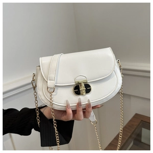 Close-up of white saddle bag featuring black-gold hardware and gold chain strap detail