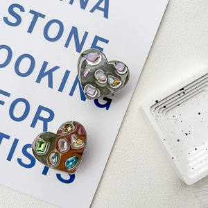 Detail of heart shaped phone grips with sparkling rhinestones and colorful gemstones