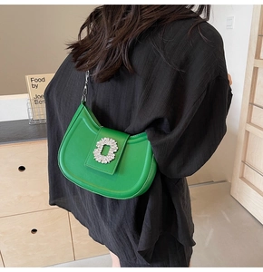 Chic green crescent bag with large crystal buckle and silver chain on model