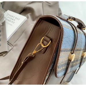 Detail of British style patchwork backpack with brown leather and plaid tweed fabric