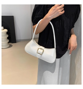 Detail of white minimalist crescent bag with glossy leather and golden metal clasp