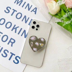 Detail of silver heart-shaped phone grip with sparkling rhinestone crystals on phone back