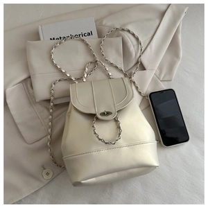 Dettaglio mini borsa a secchiello bianco panna con catena e chiusura a scatto su giacca