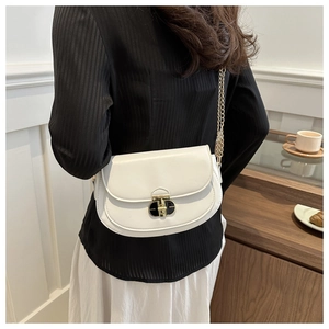 Detail of white semi-circle saddle bag with gold chain strap and black-gold twist lock