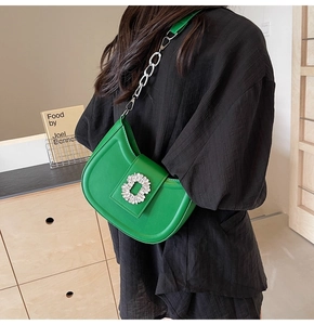 Detail of green hobo bag featuring sparkling rhinestone buckle and metallic chain strap