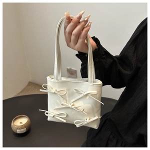 Detail shot of white shoulder bag featuring five decorative 3D bows and soft PU texture