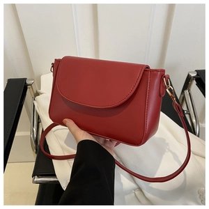Detail view of red faux leather crossbody square bag with elegant gold metal hardware