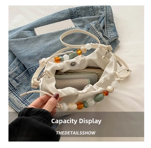 Detailed interior view of creamy bucket bag showing spacious capacity and bead handle