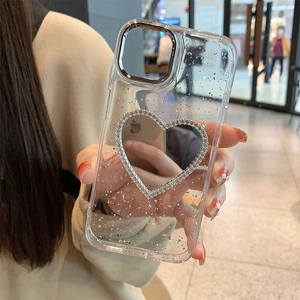 Detail of silver glitter clear iPhone case with a rhinestone heart and camera lens ring