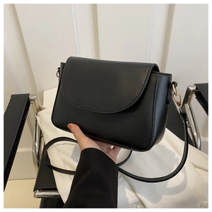 Close-up of black PU leather flap crossbody bag with elegant gold metal ring detail