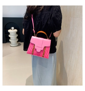 Detail shot of the pink crocodile texture and smooth faux leather on the handbag