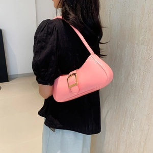 Pink minimalist underarm bag with gold square buckle shown on a model's shoulder