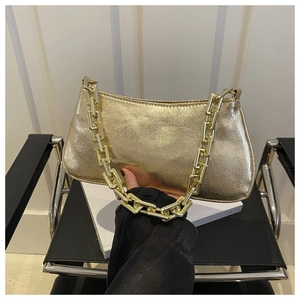 Détail du sac à bandoulière doré avec cuir texturé et une épaisse chaîne en métal doré