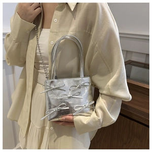 Close-up of silver bow bag details featuring metallic PU leather and bead chain