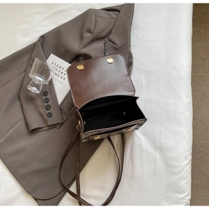 Detailed top view of vintage brown leather and plaid fabric patchwork shoulder bag