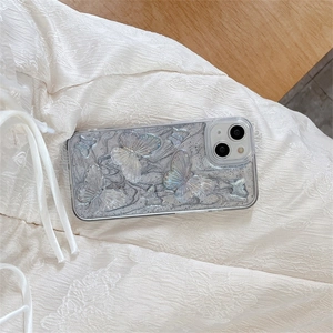 Detail of 3D iridescent butterfly ornaments on a luxury grey marble texture phone case