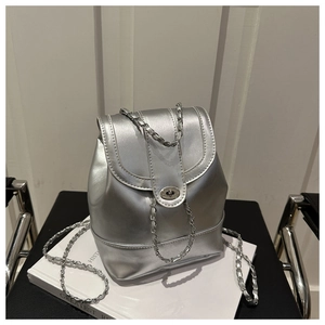 Close-up of metallic silver backpack with metal twist lock and chain strap detail