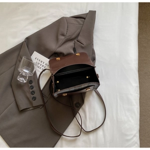 Detailed top view of a brown leather and blue fabric mix handbag with magnetic flap