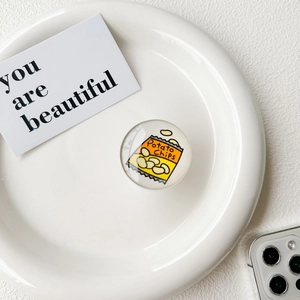 Détail d'un support de téléphone rond avec un motif de paquet de chips sur un plateau