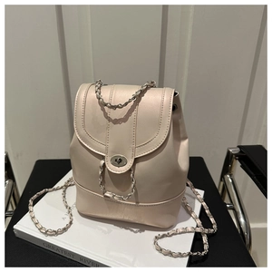 Detail of cream chain backpack featuring fine leather texture and metal turn-lock closure