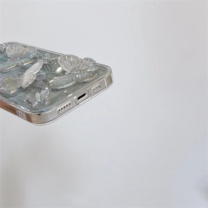 Detailed close-up of light green iPhone case with 3D resin butterfly and precise port cutouts