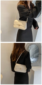 Detail of cream shoulder bag featuring a sleek rectangular gold metal buckle and flap