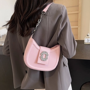 Pink quilted leather hobo bag with rhinestone buckle shown on a model shoulder