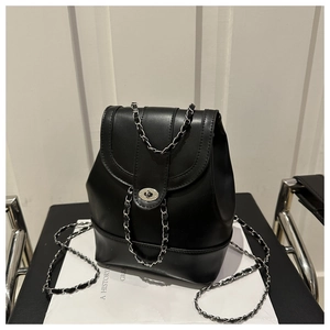 Close-up of black leather backpack with silver rotating lock and chain strap detail