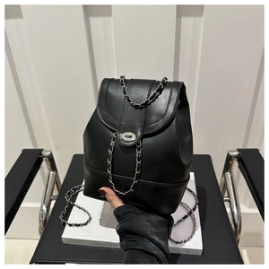Close-up of black leather backpack with silver metal chain straps and twist lock