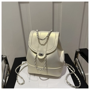 Detailed shot of cream drawstring backpack with silver chain straps and flap closure