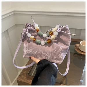 Macro detail of lavender bucket bag with unique marble texture and colorful beaded handle