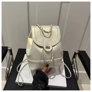 Detail of cream mini backpack with pearl finish, metal lock, and chain strap detail