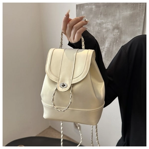 Close-up of cream mini backpack with a metallic twist lock and elegant chain strap