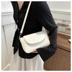Elegant white PU leather flap crossbody bag with gold hardware worn by a model