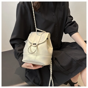 Close-up of cream white leather bucket backpack with gold chain straps and twist lock