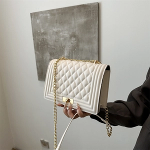 Elegant white quilted crossbody bag with gold chain strap and vintage twist lock