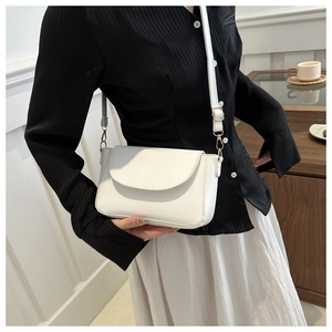 Detailed view of a white rectangular crossbody bag with curved flap and adjustable strap