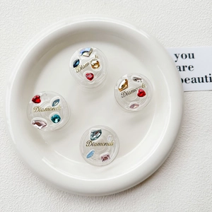 Macro shot of circular phone grips with colorful faux diamonds and Diamonds gold lettering