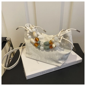 Detail of marble pattern bucket bag with colorful bead accents and drawstring closure