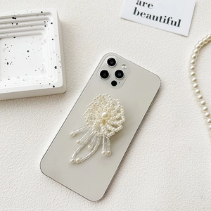 Elegant white pearl flower phone socket with hanging beaded tassels on a smartphone