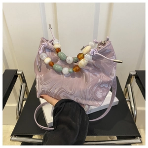 Detail of beaded handle and marble texture on light purple drawstring bucket bag