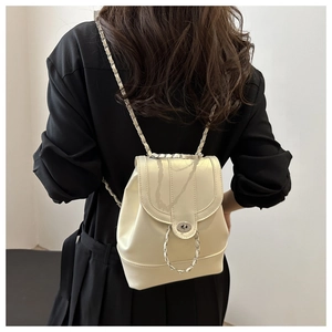 Detail of a mini cream PU leather backpack with gold metal chain and twist-lock closure