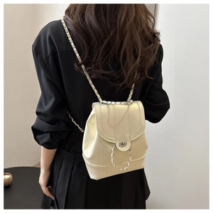 Chic pearlescent mini backpack in cream leather with silver chain straps shown on model