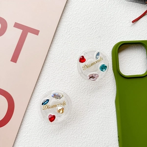 Detail of round collapsible phone grip with colorful gemstones and Diamonds text