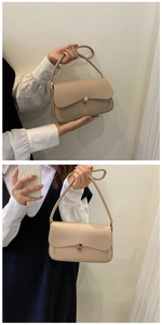 Detail of minimalist beige faux leather handbag featuring a gold-toned rectangular lock
