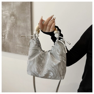 Close-up of marble texture fabric handbag with decorative multicolor beaded handles