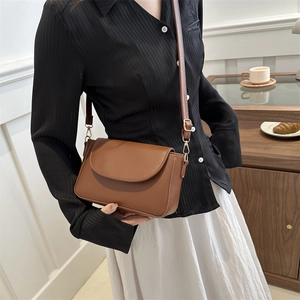 Vintage brown leather crossbody bag with rounded flap and adjustable strap for women