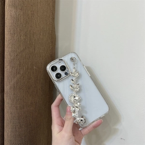 Close-up of luxury clear iPhone case featuring a brilliant rhinestone leaf hand chain strap