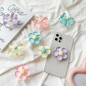 Floral and bow-shaped resin phone grip stand set on a white fabric background