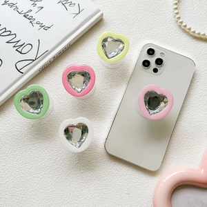 Colorful heart-shaped crystal phone grip sockets on aesthetic white background
